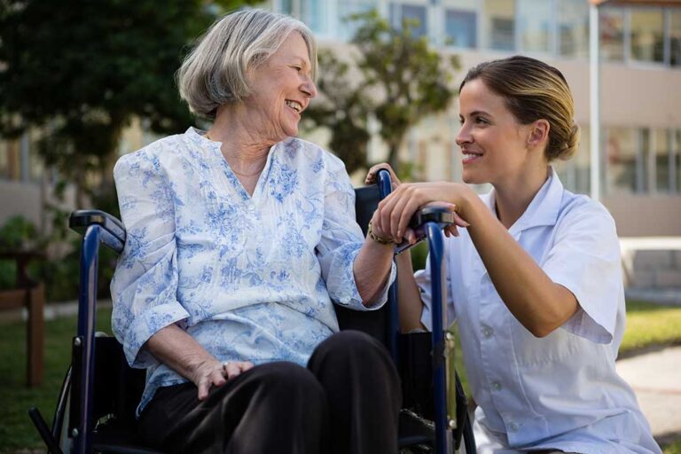 Older adult and family member reviewing care options at a table with paperwork and a walker nearby.
