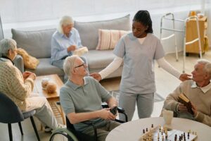 Older adult and family member reviewing a calendar and medication organizer together at a kitchen table.