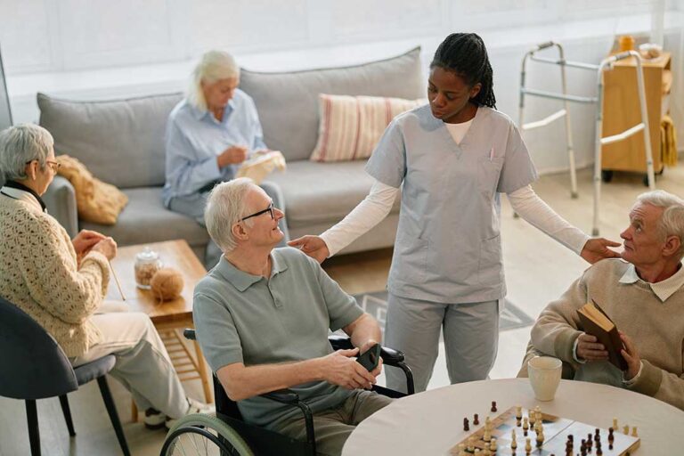 Older adult and family member reviewing a calendar and medication organizer together at a kitchen table.