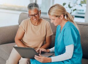 Older adult reviewing assisted living costs with a family member at a dining table beside a senior apartment floor plan.